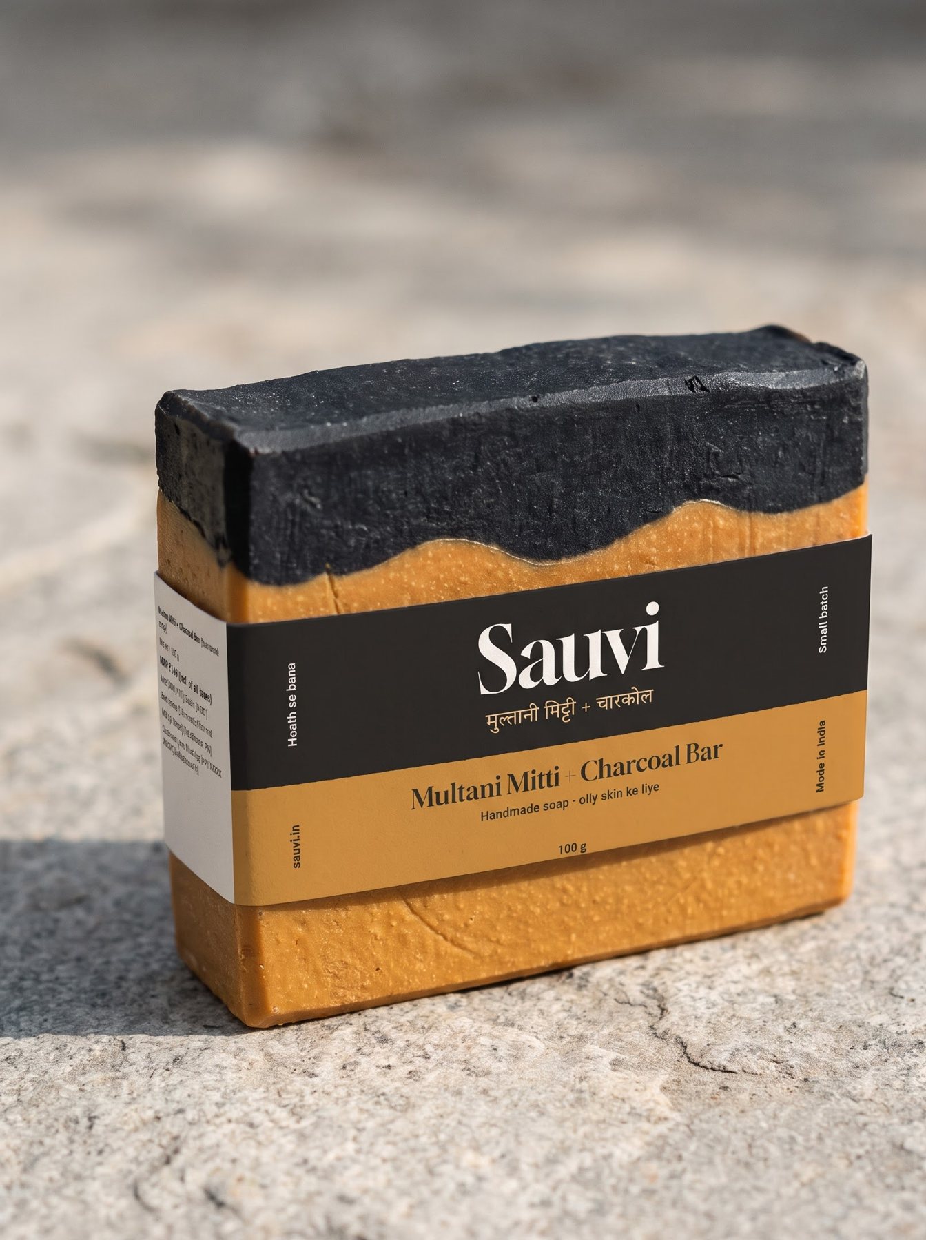 Sauvi label wala Multani Mitti + Charcoal Bar, patthar pe rakha